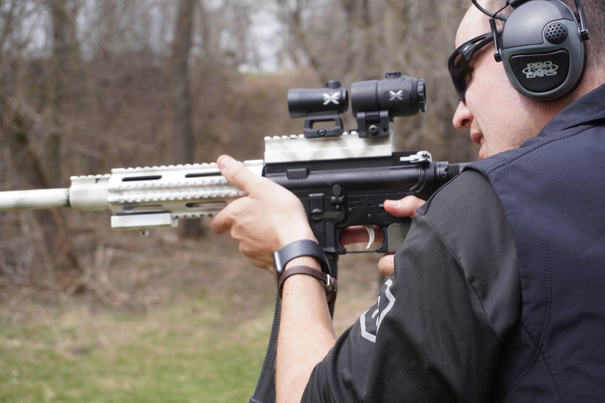 man practicing shooting with eye protection