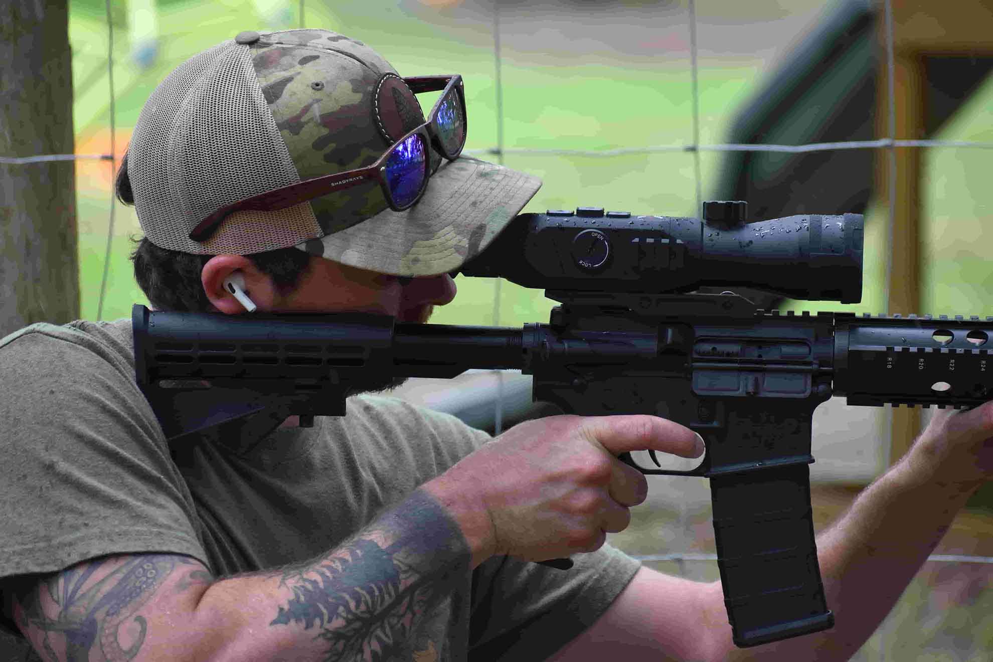 man looking through firearm scope